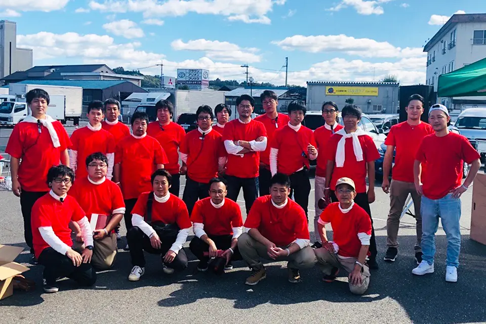 仲間との集合写真を撮る長岡さん