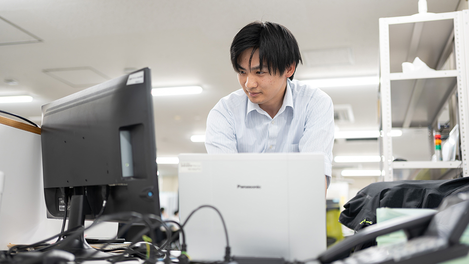 パソコンの前で作業する郷田さん