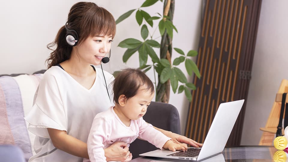 子どもと一緒にPCでWeb通話する女性