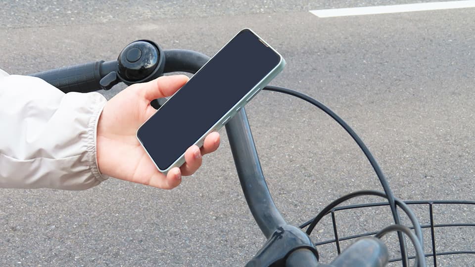 自転車に乗りながらスマホを持つ人