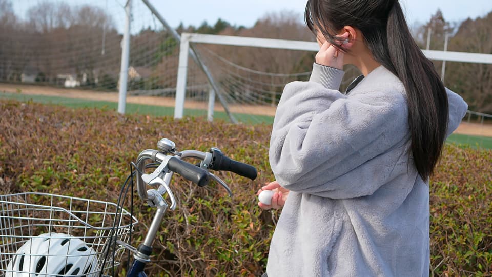 自転車に乗りながらイヤホンをつける人