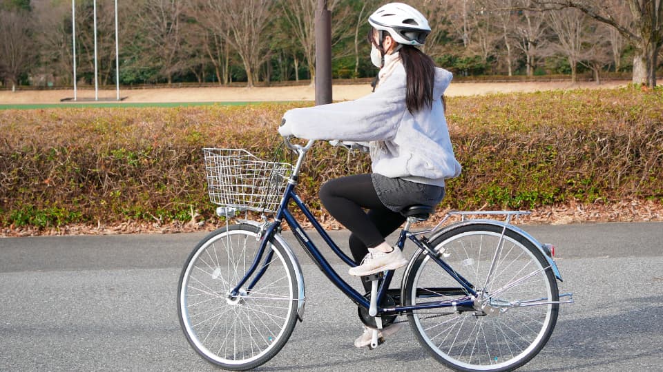ヘルメットをつけて自転車に乗る人