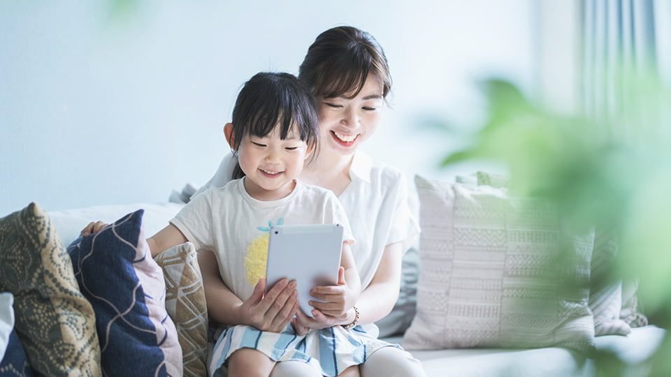 タブレットを見る母と子