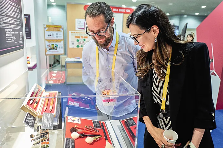 記者が伝統工芸品の展示を見る様子