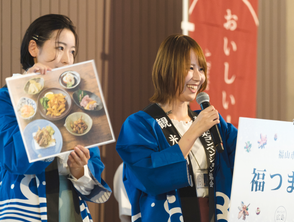 青いハッピを着た女性2人が、演説をしている写真