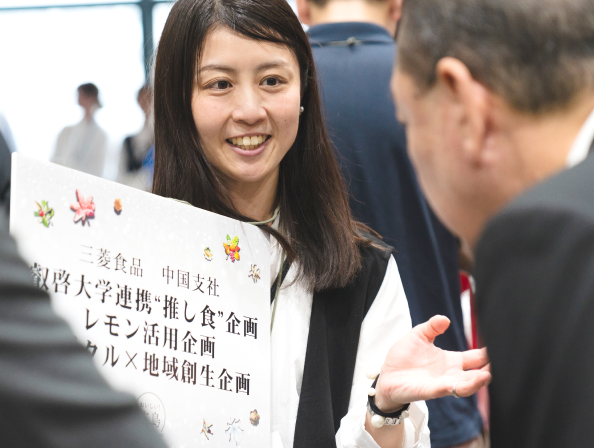 パネルを持ち、演説をする女性の写真