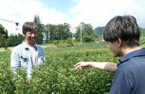 普及員と会話する栗本さん（左）