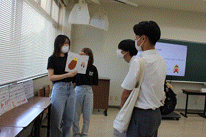 看護学生が高校生に臓器の説明をしている。