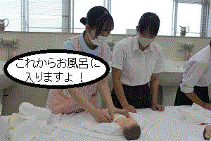 看護学生が肌着を脱がせる方法を学生に伝えている｡