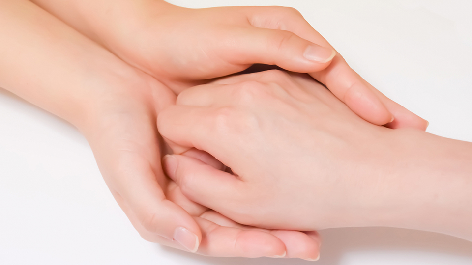 女性の手を握る女性