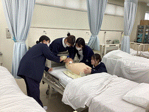 教員とバックバルブマスクを使った人工呼吸の方法を練習している