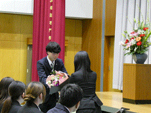 自治会から花束が贈呈されている